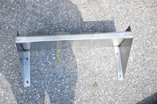 Stainless steel shelf bracket on asphalt, part of auction lot with 3 shelves and sink strainer, good condition.