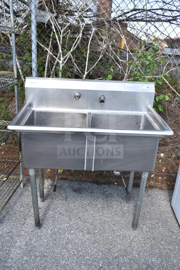 Commercial 2 Bay Sink, stainless steel, durable construction, dual basins, metal legs, some visible wear, for industrial use.