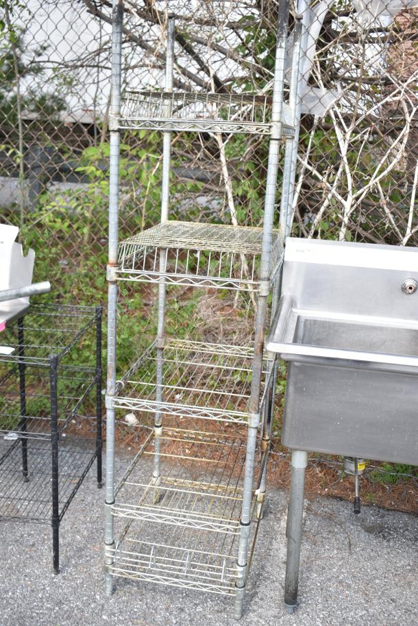 Metal shelving unit with five wire shelves. Rust visible, requires dismantling by buyer. Consider freight costs.