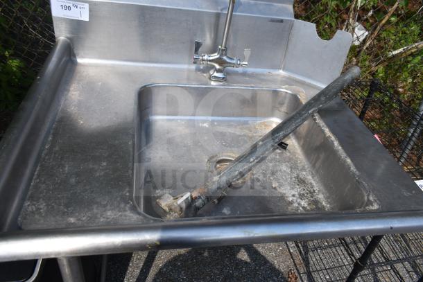Commercial left-side dirty dish table with integrated sink and faucet, stainless steel, visibly worn and weathered.