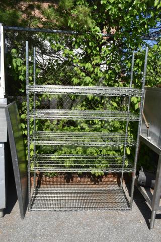Chrome finish 5-tier wire shelving unit, outdoor setting, sturdy metal construction, dismantling required for buyer.