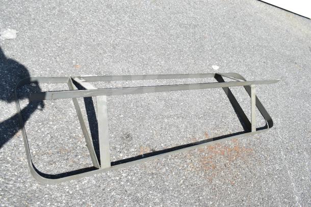 Commercial pot rack, metal, rectangular frame, moderate wear, suitable for kitchen storage.