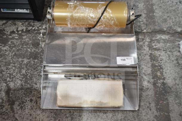 Countertop wrapping station with plastic wrap roll, 120 volts, 1 phase, stainless steel, minor wear, auction tag visible.