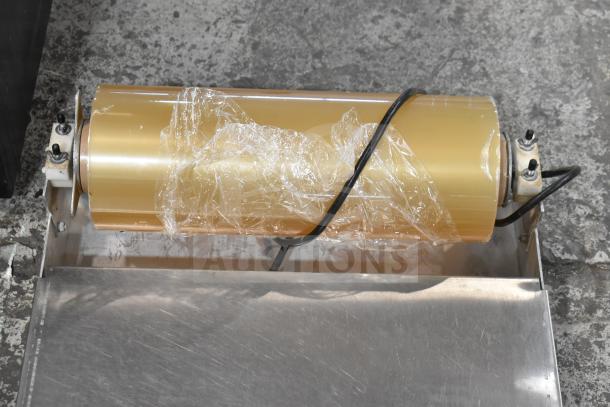 Countertop wrapping station with film roll, 120 volts, 1 phase, stainless steel surface, used condition, shows wiring.
