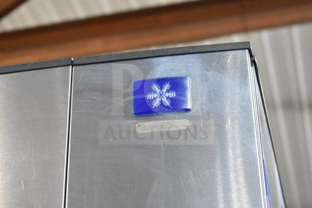 Manitowoc SD0452A ice machine head, blue snowflake logo visible, attached to Manitowoc SPA310 hotel ice dispenser.