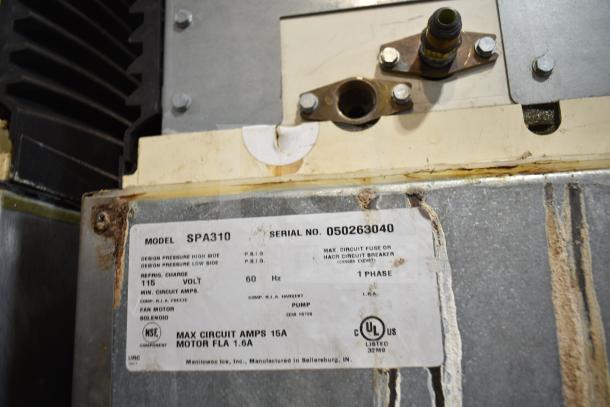 Manitowoc SPA310 dispenser label displaying model, 115V, serial number, and UL certification. Visible wear on the surface.