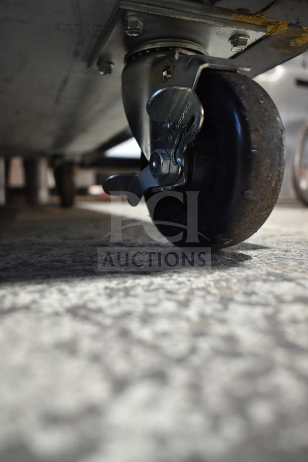 McCray GF48-CAR-BE-DHL cooler caster detail, showing a robust commercial wheel with lock, mounted on metal plate.