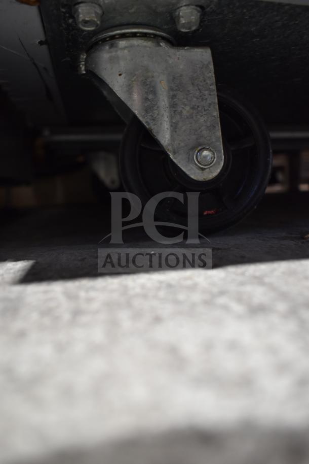 Close-up of a caster wheel on a 2022 Avantco 178SSPT60HC commercial sandwich salad prep table.