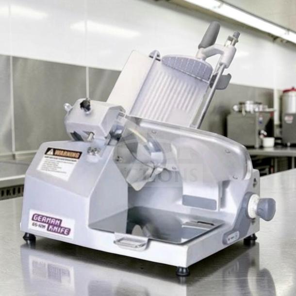 German Knife GS-12M 12” gravity feed slicer in excellent condition on stainless steel counter. UL and NSF tested.