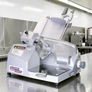 German Knife GS-12M 12” gravity feed slicer in excellent condition on stainless steel counter. UL and NSF tested.