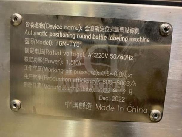 Tang Machinery TGM-TY01 labeling machine nameplate. Displays model, voltage, power, pressure, efficiency, and manufacturing date.