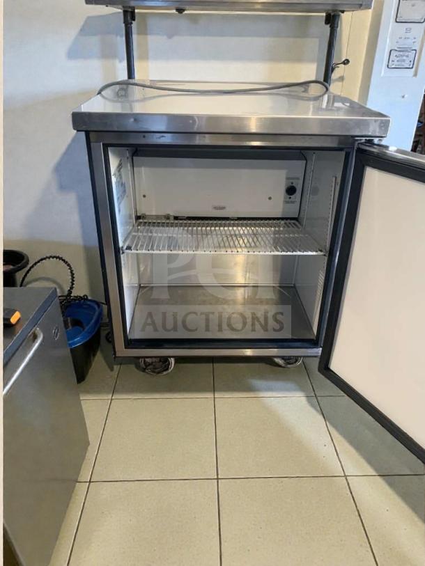 True TUC-27-LP undercounter refrigerator in immaculate condition, open door view, single shelf, stainless steel exterior. Fully tested.
