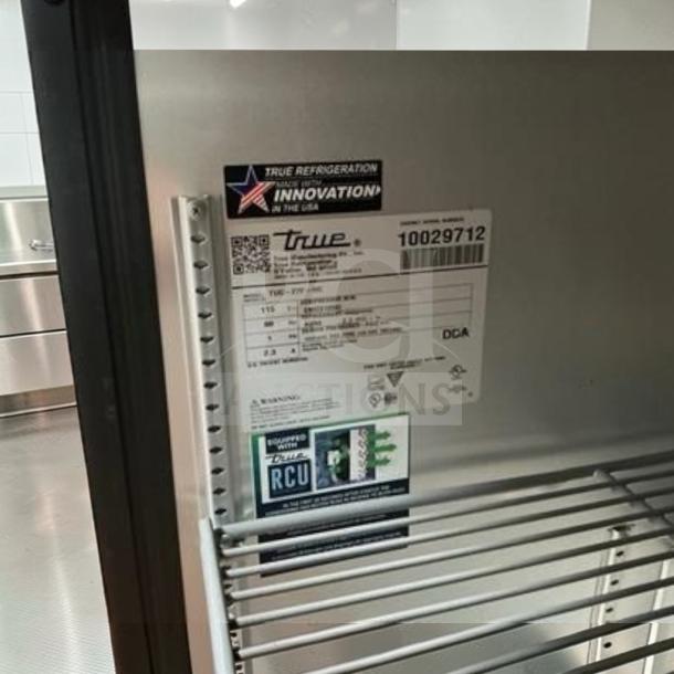 Flawless True TUC-27F-HC undercounter freezer, stainless steel, left hinge door. Labels state model and operational specs. Made in USA.