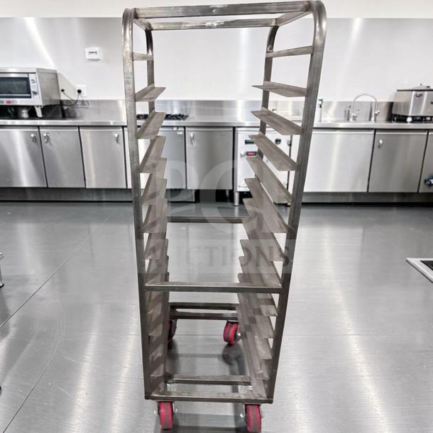 Commercial stainless steel bun pan rack, mobile with red casters. Heavy-duty, excellent condition, holds multiple trays. Safe for bakery use.