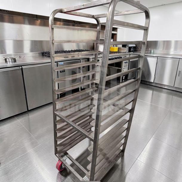 Commercial stainless steel bun pan rack, mobile and heavy-duty, in superior condition. Features multiple tray slots, red caster wheels.