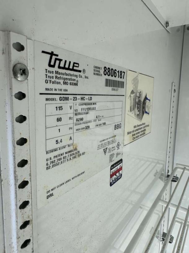 True GDM-23-HC commercial glass door merchandiser label showing model, voltage (115V), refrigerant (R290), and serial number.