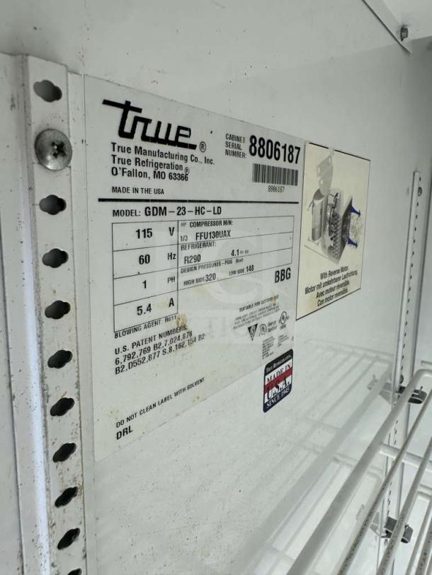 True GDM-23-HC 27" Commercial Glass Door Merchandiser label showing model, voltage, and refrigerant details.