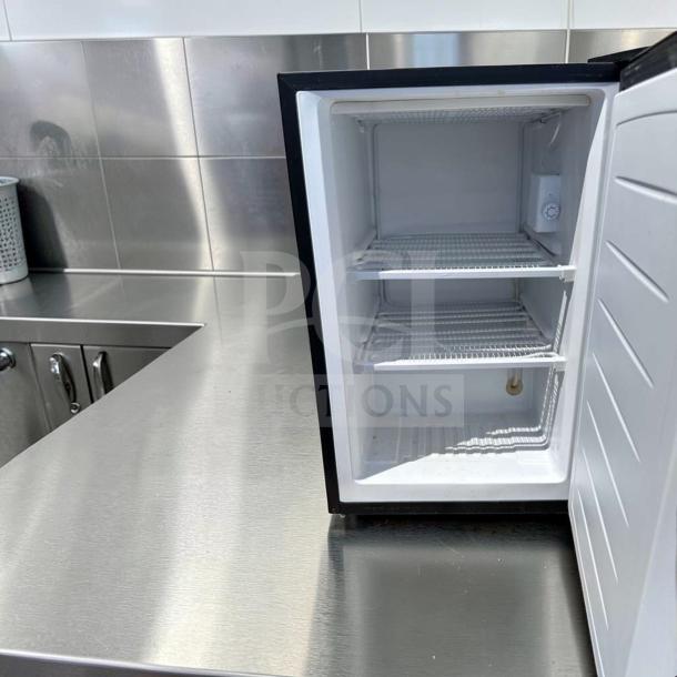 Magic Chef MCUF3S2 3 Cu. Ft. compact upright fridge in excellent condition, stainless steel, open door showing shelves.