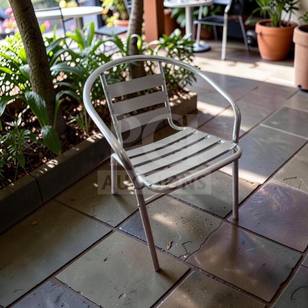 Silver Lancaster Table & Seating outdoor arm chair, commercial-grade, stackable, powder-coated steel, inspected in excellent condition.