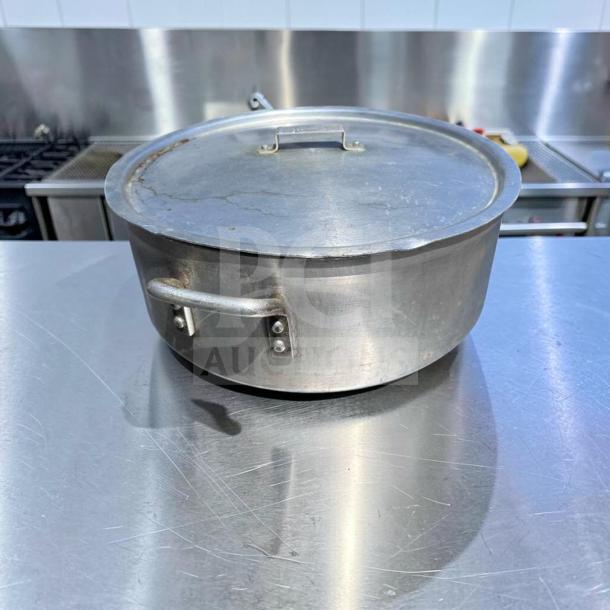 Heavy-duty commercial aluminum stock pot with lid, large capacity, superior condition, ideal for restaurant use.