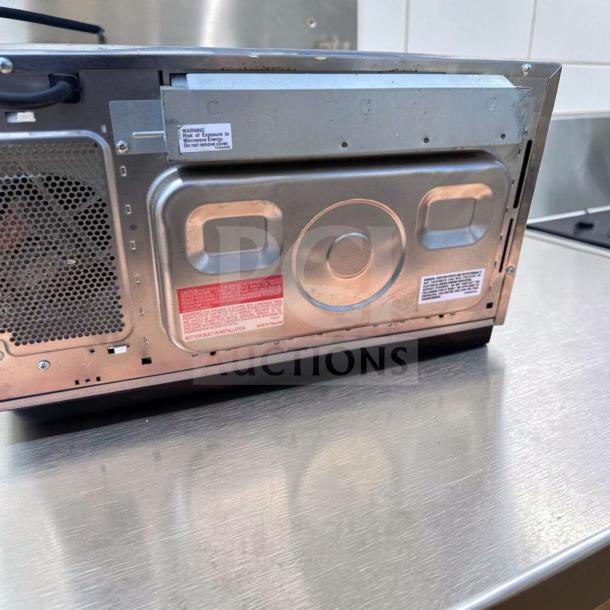 Sharp R-21LCFS Commercial Microwave Oven, stainless steel back view, 1000W, 120V, visible safety and operation labels, excellent condition.