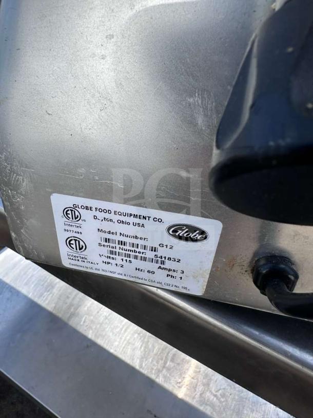 Elite Condition Globe G12 12" manual meat slicer by Globe Food Equipment Co., 1/2 HP, heavy-duty, tested operational. ETL labels visible.