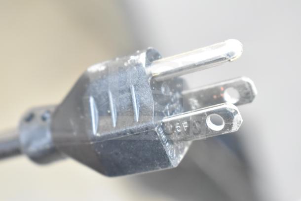 Close-up of a power plug for a Robot Coupe R2BCLR food processor, 1 hp, 120 Volts, 1 Phase. Plug shows minor wear.