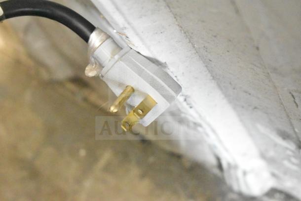 Close-up of a True GDM-41SL-54-HC-LD cooler merchandiser's power plug, showing a three-pronged connector for 115 volts, 1 phase.