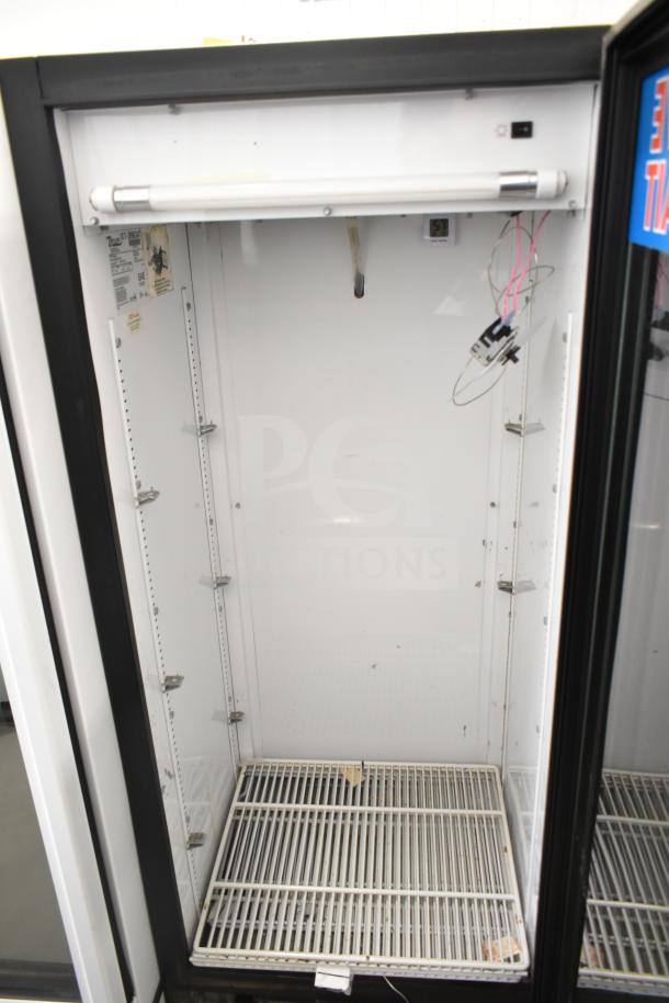 True GDM-12 commercial single-door reach-in cooler merchandiser. 115 volts, 1 phase. Interior shows adjustable shelving brackets.