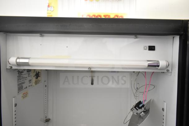 True GDM-12 commercial single door reach-in cooler interior, showing fluorescent light and wiring. Model label visible.