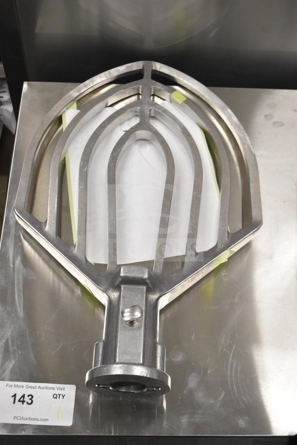 Brand new Hobart 00-874654 beater paddle on metal surface; auction tag visible.