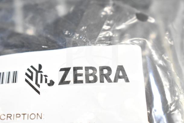 Four brand new Zebra charging cups and cables, sealed in original packaging, with visible Zebra logo and barcode.