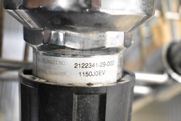 Close-up of a gauge showing model number 2122341-29-000 and serial number 1150JOEV. Features metal and plastic components.