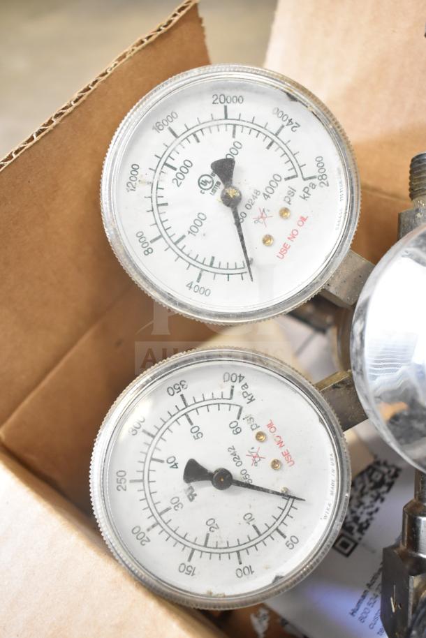 Dual pressure gauge with clear dials, showing PSI and kPa. Marked "USE NO OIL". Slight wear visible.