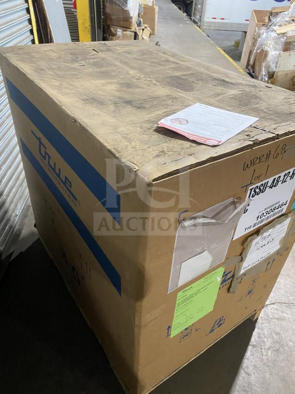 Brand new True TSSU4812HC refrigerated sandwich prep table in box, 115V, 1 phase, on casters; Serial 1030846 visible.