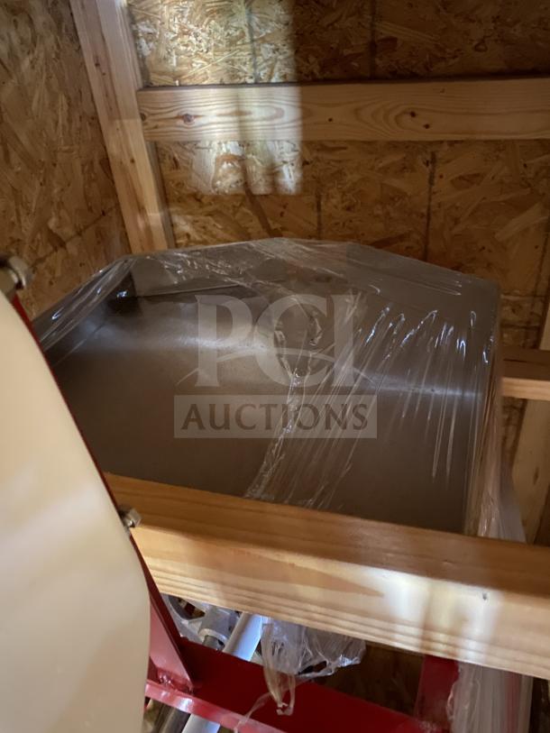 Brand new Meadows Mills MQ098 steel burr grain mill, wrapped in plastic, on a wooden crate. Model MQ098, 220V, 1 Phase.