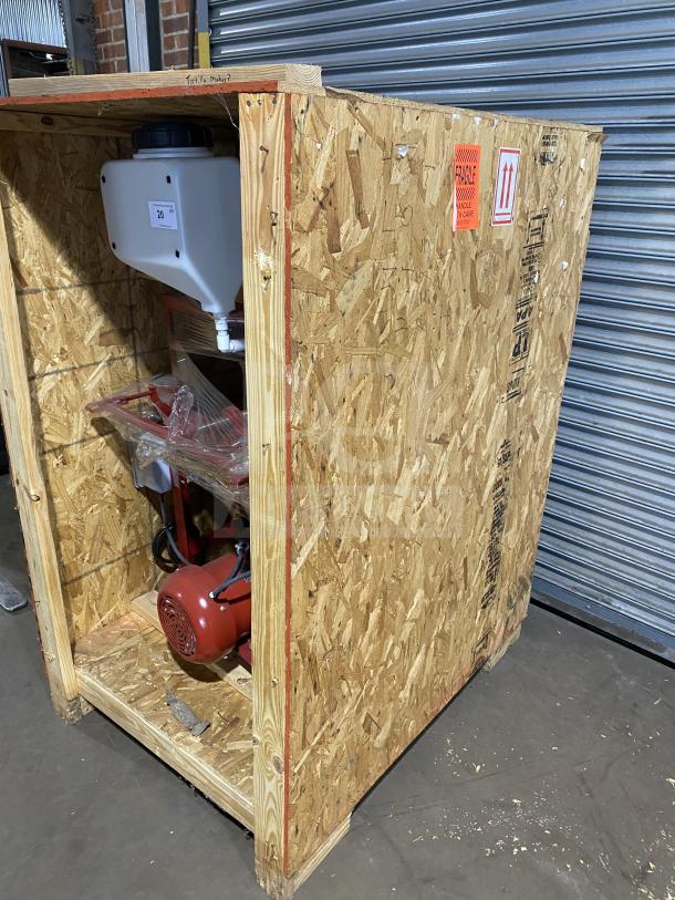 Brand new Meadows Mills MQ098 grain mill in crate. Model MQ098, 220V, 1 phase, red motor, "Fragile" label visible.