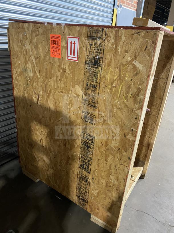 New Meadows Mills Steel Burr Grain Mill, Model MQ098, still in crate. Features 220V, 1 Phase. Labels show handling instructions.