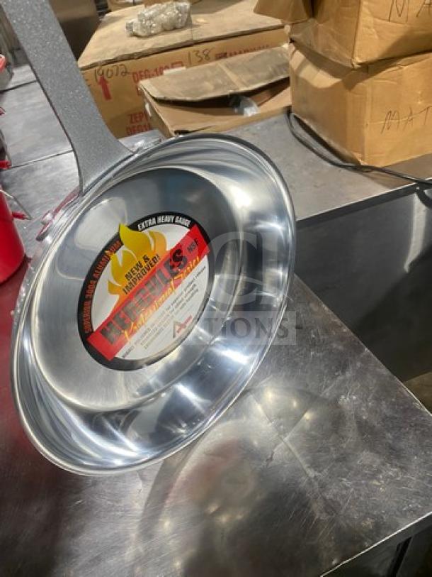 Brand new Adcraft stainless steel skillet, sizzling/frying model. Heavy-duty grade, label indicates durability and make.