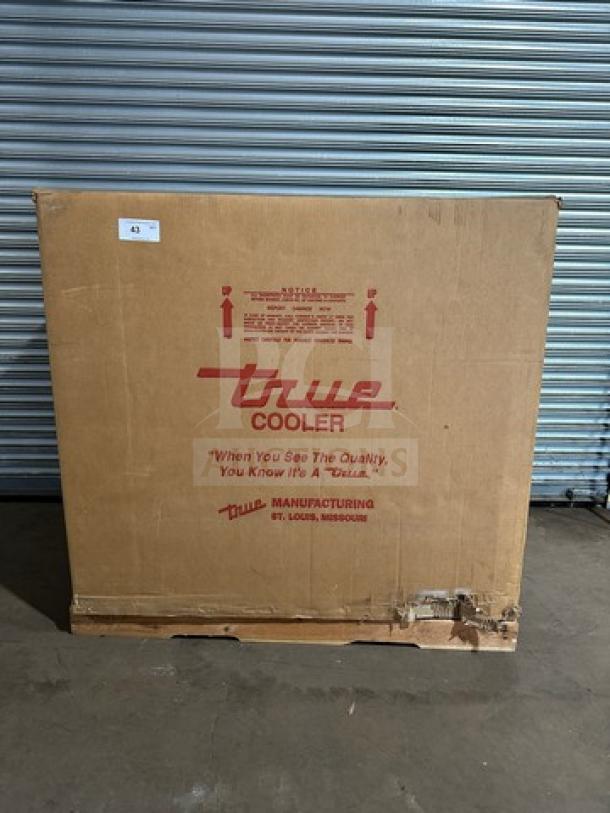 Brand new True THAC48LD refrigerated merchandiser in sealed box. Model and serial number visible. 115V, 1 phase.