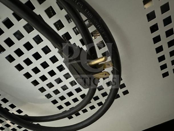 Power cord of the True THAC48LD Grab-N-Go Refrigerated Merchandiser, showcasing a 115V plug against a vented panel.