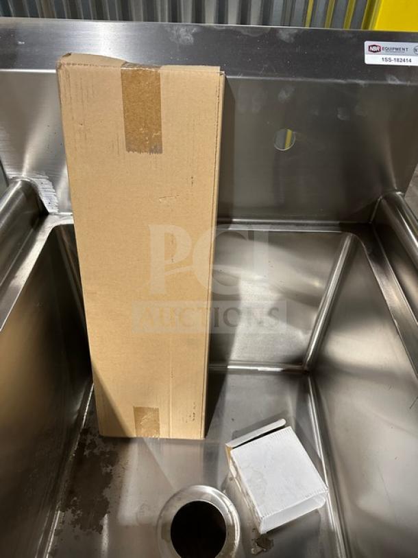 Brand new NBR stainless steel prep sink, model 182414, includes legs and strainer. Shown with packaging in basin.