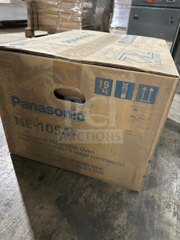 Brand new Panasonic NE1054F microwave in box, features digital touch pad, 120V 1 phase, 19kg weight marked on packaging.