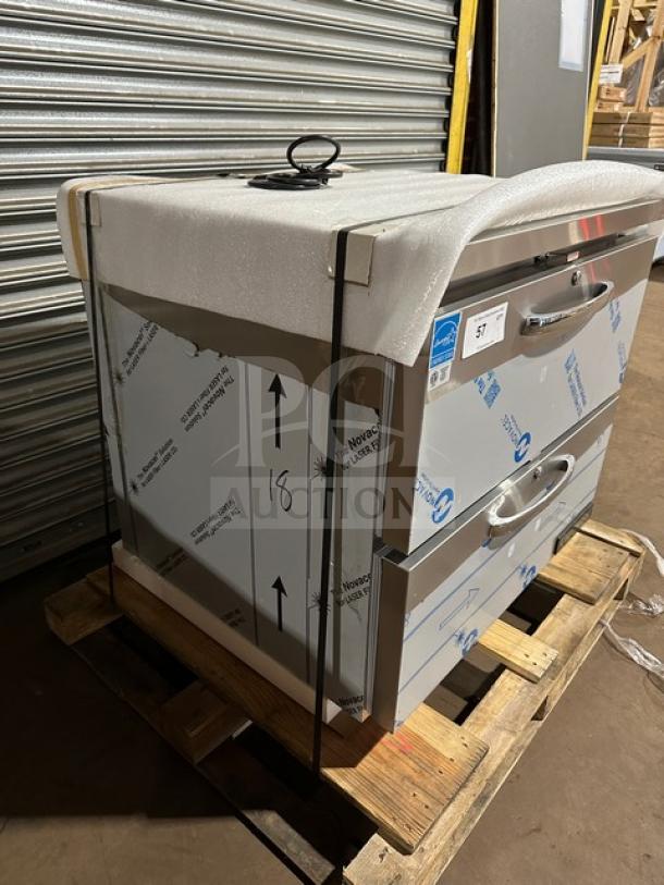 Brand new Continental SW32N 2-drawer refrigerated lowboy cooler, 115V, in packaging on a pallet, visible model and serial label.