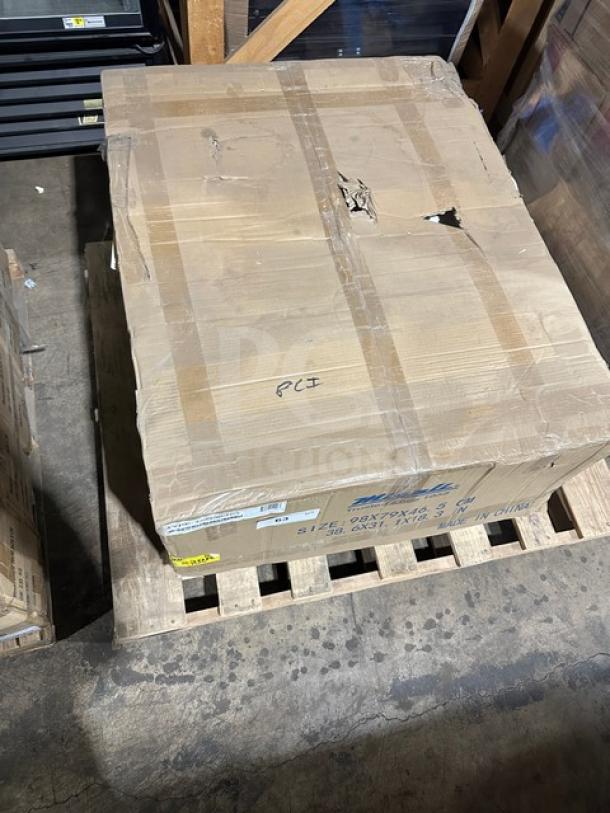 A large cardboard box labeled "Imperial" on a wooden pallet, showing signs of wear and a torn area, in a warehouse setting.