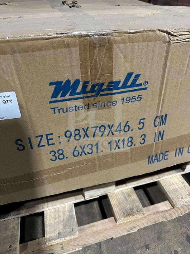 Cardboard box labeled "Migali, Trusted since 1955" with dimensions 98x79x46.5 cm. Box on a wooden pallet.