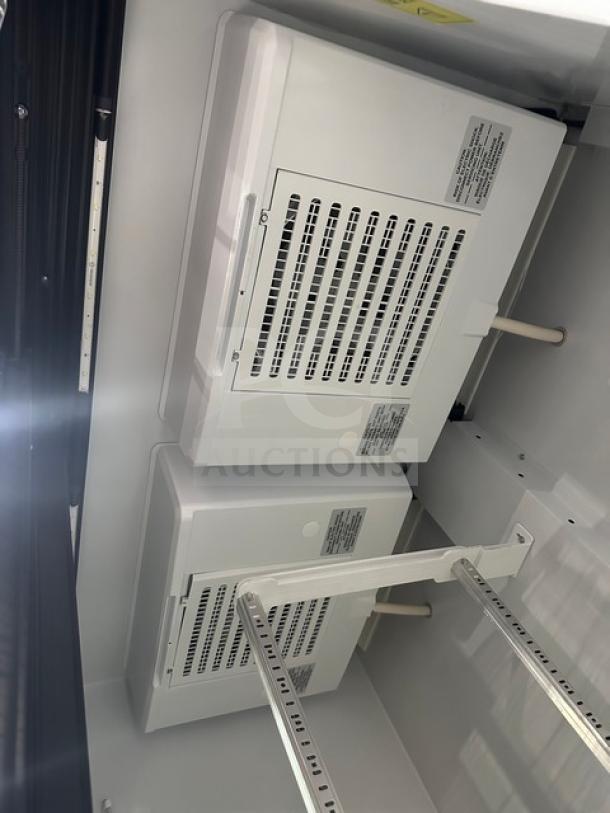 Beverage Air refrigeration unit interior with vented panels and metal shelving, showing control labels, clean condition.