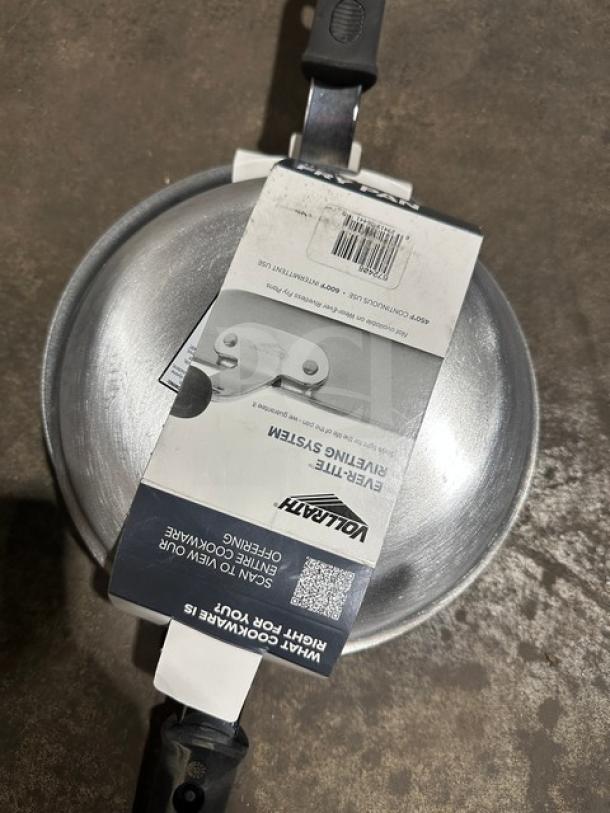 Vollrath frying pan with label, showcasing venting system. Brand tag visible. New condition. Durable handle, metallic finish.