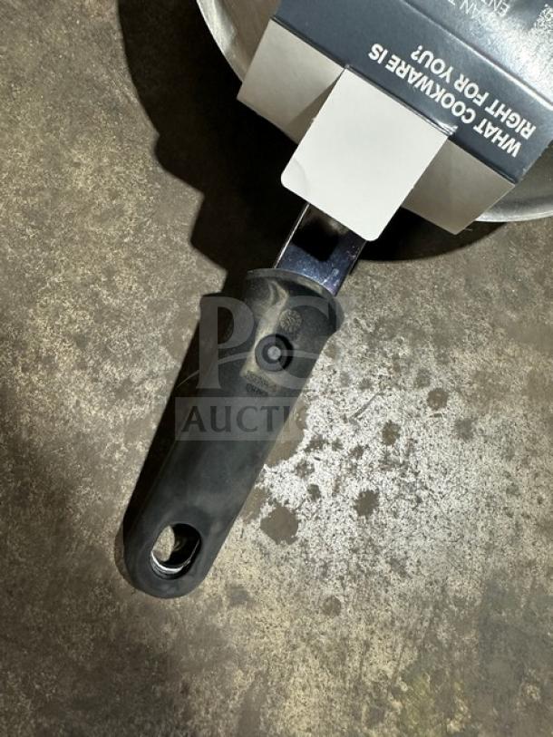 Vollrath frying pan with a black ergonomic handle. Packaging label partially visible, indicating cookware quality. Appears in good condition.
