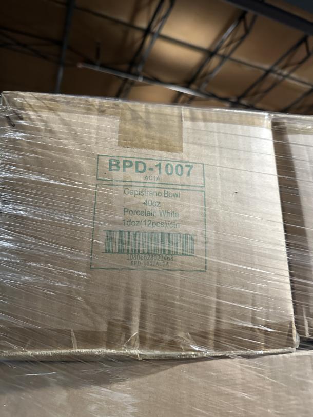 Auction image of a mixed pallet with various boxed items, including BPD-1007 AC1A Capistrano Bowl, 40 oz, porcelain, white, 12 pieces per carton.